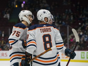 Edmonton Oilers defenceman Evan Bouchard (75) and forwards Ryan Nugent-Hopkins (93) and Kyle Turris (8) celebrate Bouchard’s goal against the Vancouver Canucks at Rogers Arena on Saturday, Oct. 9, 2021.