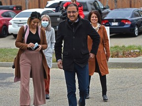 Amarjeet Sohi with his wife Sarbjeet, right, and daughter Seerat walk up to the polling station to vote at Father Michael Troy School in southeast Edmonton on Monday, Oct. 18, 2021.