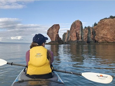 Meike Holst takes in the beauty of the three sisters sea stacks in the Bay of Fundy. The sea stacks are remnants of lava flows and magma intrusions from deep within the Earth. Pamela Roth