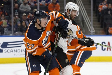 The Edmonton Oilers' Tyson Barrie (22) battles the Anaheim Ducks' Adam Henrique (14) during second period NHL action at Rogers Place, in Edmonton Tuesday Oct. 19, 2021.