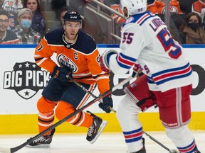 Edmonton Oilers' Connor McDavid (97) is chased by New York Rangers' Ryan Lindgren (55) during first period NHL action at Rogers Place in Edmonton, on Friday, Nov. 5, 2021.