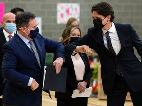 Prime Minister Justin Trudeau, right, and Alberta Premier Jason Kenney bump elbows during a joint federal-provincial announcement of $10-a-day daycare at Boyle Street Plaza in Edmonton, on Monday, Nov. 15, 2021.