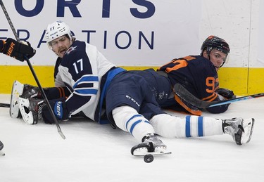 Edmonton Oilers Connor McDavid (97) and Winnipeg Jets Adam Lowry (17) watch the puck during first period NHL action on Thursday, Nov. 18, 2021 in Edmonton.