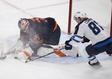 Edmonton Oilers goalie Stuart Skinner (74) covers the puck from Winnipeg Jets Kyle Connor (81) during second period NHL action on Thursday, Nov. 18, 2021 in Edmonton.