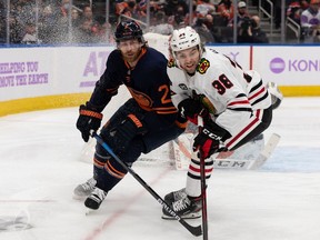 Edmonton Oilers' Duncan Keith (2) battles Chicago Blackhawks' Brandon Hagel (38) during second period NHL action at Rogers Place in Edmonton, on Saturday, Nov. 20, 2021.