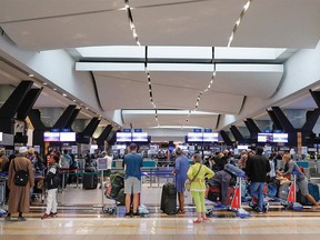 Travellers queue at a check-in counter at OR Tambo International Airport in Johannesburg on November 27, 2021, after several countries banned flights from South Africa following the discovery of a new COVID-19 variant Omicron.