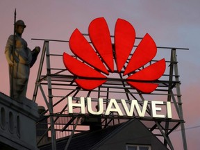 The logo of Chinese telecommunications giant Huawei Technologies is pictured next to a statue on top of a building in Copenhagen, June 23, 2021.