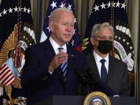U.S. President Joe Biden (left) speaks as Attorney General Merrick Garland listens during a bill signing ceremony in the State Dining Room of the White House in Washington, D.C., Thursday, Nov. 18, 2021.