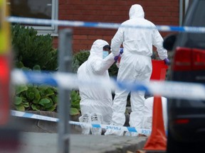 A police officer searching an area puts an item into a box at the scene of a car blast outside Liverpool Women's Hospital, in Liverpool, England, Monday, Nov. 15, 2021.