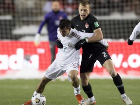 Team Canada's Alistair Johnston (2) and Team Mexico's Hirving Rodrigo Lozano Bahena (22) battle for the ball during FIFA 2022 World Cup qualifier soccer match held at Commonwealth Stadium on Tuesday, Nov. 16, 2021 in Edmonton.