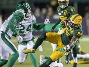 Edmonton Elks' Jalen Tolliver (88) is tripped up by Saskatchewan Roughriders' Ed Gainey (11) as Jeremy Clark (37) and Damon Webb (24) look on during first half CFL action in Edmonton., on Friday, Nov 5, 2021.