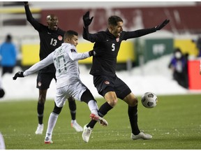CP-Web.  Canada's Steven Vitória (5) and Mexico's Orbelin Pineda Alvarado (10) via for the ball during World Cup Qualifiers in Edmonton, Tuesday, Nov. 16, 2021.