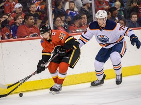 Calgary Flames' Luke Philp and Edmonton Oilers' Dmitri Samorukov fight for the possession of the puck during the battle of Alberta prospects game at Scotiabank Saddledome in Calgary on Sept. 10, 2019.
