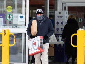 Boxing Day shoppers enter and exit a Best Buy store in Edmonton on Sunday, Dec. 26, 2021.