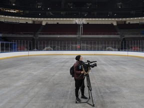 A journalist films on the surface where NHL stars would have been playing at the Wukesong Sports Center in Beijing, China.