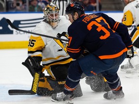 The Edmonton Oilers’ Warren Foegele (37) battles Pittsburgh Penguins goaltender Tristan Jarry (35) at Rogers Place in Edmonton on Wednesday, Dec. 1, 2021.