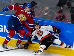 Edmonton Oil Kings defenceman Kaiden Guhle (4) knocks down the Medicine Hat Tigers’ Oasiz Wiesblatt (7) at Rogers Place in Edmonton on Friday, Dec. 3, 2021.