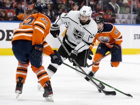 Edmonton Oilers Tyson Barrie (22) and Kailer Yamamoto (56) battle the Los Angeles Kings' Phillip Danault (24) at Rogers Place in Edmonton on Sunday, Dec. 5, 2021.