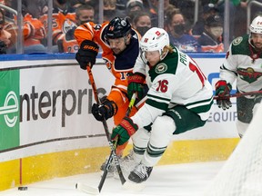 Edmonton Oilers’ Devin Shore (14) battles Minnesota Wild’s Rem Pitlick (16) during third period NHL action at Rogers Place in Edmonton, on Tuesday, Dec. 7, 2021.