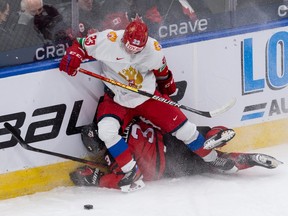Team Canada’s Olen Zellweger (3) is hit by Team Russia’s Dmitri Zlodeyev (23) during first period of IIHF World Junior Championship exhibition play at Rogers Place in Edmonton, on Thursday, Dec. 23, 2021.
