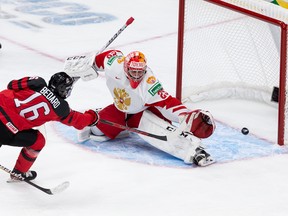 Connor Bedard (16) d'Équipe Canada marque contre le gardien de but de l'équipe russe Yegor Guskov (29) lors de la troisième période du match hors-concours du Championnat mondial junior de l'IIHF au Rogers Place à Edmonton, le jeudi 23 décembre 2021.