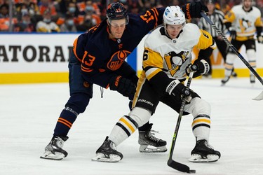 Edmonton Oilers' Jesse Puljujarvi (13) battles Pittsburgh Penguins' John Marino (6) during first period NHL action at Rogers Place in Edmonton, on Wednesday, Dec. 1, 2021.