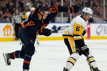 Edmonton Oilers' Jesse Puljujarvi (13) battles Pittsburgh Penguins' John Marino (6) during first period NHL action at Rogers Place in Edmonton, on Wednesday, Dec. 1, 2021.