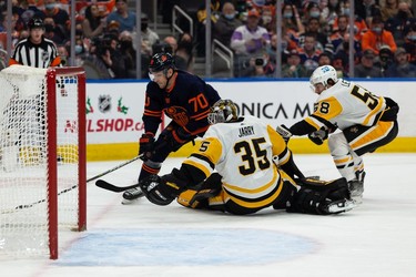 Edmonton Oilers' Colton Sceviour (70) is hooked by Pittsburgh Penguins' Kris Letang (58), who drew a penalty, during first period NHL action at Rogers Place in Edmonton, on Wednesday, Dec. 1, 2021.