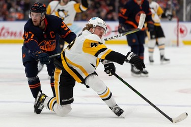 Edmonton Oilers' Connor McDavid (97) battles Pittsburgh Penguins' Kasperi Kapanen (42) during second period NHL action at Rogers Place in Edmonton, on Wednesday, Dec. 1, 2021.
