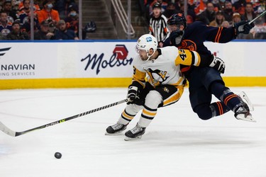 Edmonton Oilers' Tyson Barrie (22) is hit by Pittsburgh Penguins' Dominik Simon (49) during second period NHL action at Rogers Place in Edmonton, on Wednesday, Dec. 1, 2021.