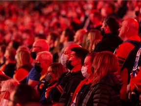 Hockey fans are seen during the national anthem singing as the Edmonton Oilers play the Pittsburgh Penguins during a NHL game at Rogers Place in Edmonton, on Wednesday, Dec. 1, 2021.