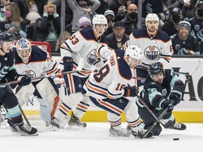 Seattle Kraken right wing Joonas Donskoi (72) and Edmonton Oilers left wing Zach Hyman (18) battle for the puck in front of Seattle Kraken left wing Jared McCann (16), left, Edmonton Oilers goalkeeper Stuart Skinner (74), center Ryan Nugent-Hopkins (93) and defenceman Kris Russell (6) at Climate Pledge Arena on Dec. 3, 2021.