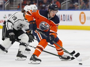 Edmonton Oilers forward Ryan McLeod (71) carries the puck while Los Angeles Kings forward Alex Iafallo (19) tires to knock it away from him at Rogers Place on Dec. 5, 2021.