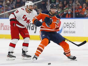 Edmonton Oilers defensemen Markus Neimelainen (80) and Carolina Hurricanes forward Vincent Trocheck (16) chase a loose puck during the first period at Rogers Place.