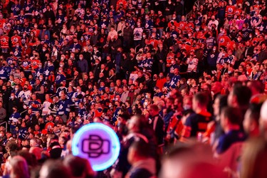 Hockey fans sing the national anthem as the Edmonton Oilers play the Toronto Maple Leafs during a NHL game at Rogers Place in Edmonton, on Tuesday, Dec. 14, 2021.