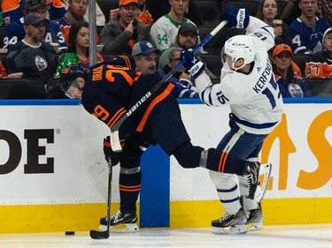 Edmonton Oilers' Leon Draisaitl (29) battles Toronto Maple Leafs' Alexander Kerfoot (15) during second period NHL action at Rogers Place in Edmonton, on Tuesday, Dec. 14, 2021.