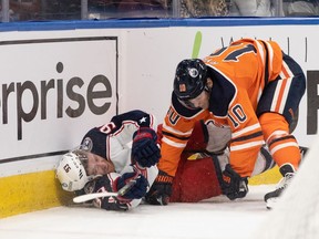 Edmonton Oilers' Derek Ryan (10) knocks down Columbus Blue Jackets' Jakub Voracek (93) during second period NHL action at Rogers Place in Edmonton, on Thursday, Dec. 16, 2021.