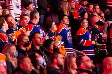 Hockey fans sing the national anthem as the Edmonton Oilers take on the Columbus Blue Jackets during a NHL game at Rogers Place in Edmonton, on Thursday, Dec. 16, 2021.
