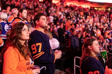 Hockey fans sing the national anthem as the Edmonton Oilers take on the Columbus Blue Jackets during a NHL game at Rogers Place in Edmonton, on Thursday, Dec. 16, 2021. =