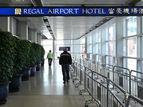 People head towards the Regal Airport Hotel at Chek Lap Kok airport in Hong Kong on November 26, 2021, where a new COVID-19 variant deemed a 'major threat' was detected in a traveller from South Africa and who has since passed it on whilst in quarantine.