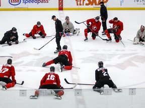 Players stretch as head coach Dave Cameron, centre left, gives instruction during a practice at the Canadian World Junior Hockey Championships selection camp in Calgary, Thursday, Dec. 9, 2021.