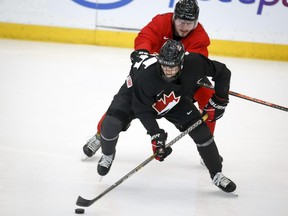 Shane Wright, left, and Mason McTavish skate during a practice at the Canadian world junior hockey championship selection camp in Calgary on Dec. 11, 2021.