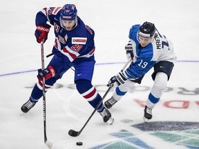 United States' Red Savage (20) and Finland's Juuso MŠenpŠŠ (19) battle for the puck during second period IIHF World Junior Hockey Championship exhibition action in Edmonton on Thursday, December 23, 2021.