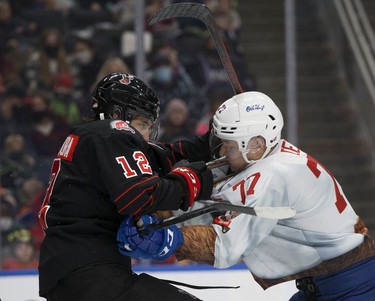 The Edmonton Oil Kings' Jakub Demek (77) battle the Moose Jaw Warriors' Majid Kaddoura (12) during first period WHL action at Rogers Place, in Edmonton Saturday Dec. 4, 2021.