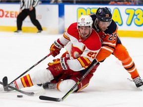 Leon Draisaitl (29) of the Edmonton Oilers battles Sean Monahan (23) of the Calgary Flames at Rogers Place on Jan. 22, 2022, in Edmonton.