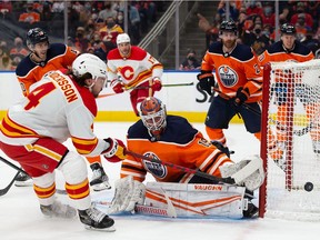 EDMONTON, AB - JANUARY 22: Rasmus Andersson #4 of the Calgary Flames takes a shot against goaltender Mikko Koskinen #19 of the Edmonton Oilers during the first period at Rogers Place on January 22, 2022 in Edmonton, Canada.