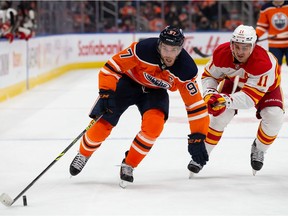 Connor McDavid #97 of the Edmonton Oilers battles against Mikael Backlund #11 of the Calgary Flames during the second period at Rogers Place on January 22, 2022.