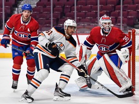Evander Kane (91) of the Edmonton Oilers skates against Ben Chiarot (8) of the Montreal Canadiens and goaltender Sam Montembeault (35) at Bell Centre on Jan. 29, 2022.
