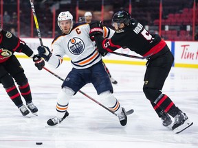 Connor McDavid #97 of the Edmonton Oilers battles Nick Holden #5 of the Ottawa Senators for positioning during their game at the Canadian Tire Centre on January 31, 2022 in Ottawa.