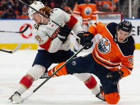 Edmonton Oilers’ Ryan McLeod (71) is hit by Florida Panthers’ Owen Tippett (74) at Rogers Place in Edmonton on Thursday, Jan. 20, 2022.